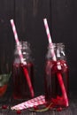 Homemade red pomegranate lemonade in small glass bottles