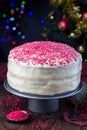 Homemade red velvet cake with cream cheese frosting and red sugar decoration, low key photo with boke lights and christmas Royalty Free Stock Photo