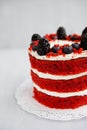 Homemade red velvet cake decorated with berries on a light wooden background Royalty Free Stock Photo