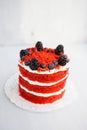 Homemade red velvet cake decorated with berries on a light wooden background Royalty Free Stock Photo