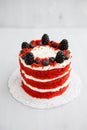 Homemade red velvet cake decorated with berries on a light wooden background Royalty Free Stock Photo