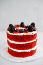 Homemade red velvet cake decorated with berries on a light wooden background Royalty Free Stock Photo