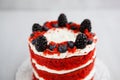 Homemade red velvet cake decorated with berries on a light wooden background Royalty Free Stock Photo