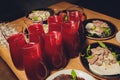 Homemade red wine sangria with orange, apple, strawberry and ice in pitcher and glass on rustic wooden background.