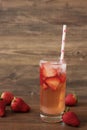 Homemade refreshing strawberry lemonade, fresh strawberries, wood background