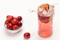 Homemade refreshing summer apple drink with ice in glass. Sliced apples on stick. Small red apples in glass cup