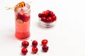 Homemade refreshing summer apple drink with ice in glass. Sliced apples on stick. Small red apples on table and in glass cup