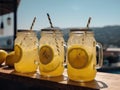 Homemade refreshing summer lemonade drink with lemon slices and ice in mason jars, in open air caffe on sea coast.