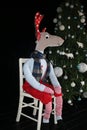 Homemade reindeer sat on chair by Christmas tree