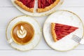 Homemade rhubarb and strawberry pie and cup of coffee cappuccino on white wooden table. Royalty Free Stock Photo