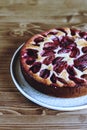 Homemade Ricotta Plum Cake on wooden table. Cottage cheese casserole