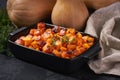 Homemade roasted butternut squash cubes with thyme on a black stone table Royalty Free Stock Photo
