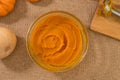 Homemade roasted pumpkin puree from scratch. Fresh puree in a glass bowl close up on kitchen table