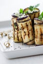 Homemade rolled eggplant (aubergine) grilled appetizers with cottage cheese, nuts, black sesam and parsley