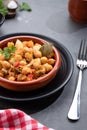 Homemade Ropa vieja, typical Canarian dish of chickpeas stew with chicken and potatoes in a earthenware casserole on marble table Royalty Free Stock Photo