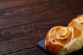 Homemade rose buns on stony cutting board over rustic vintage background, close-up, shallow depth of field Royalty Free Stock Photo