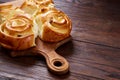 Homemade rose buns on wooden cutting board over rustic vintage background, close-up, shallow depth of field Royalty Free Stock Photo