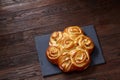 Homemade rose buns on wooden cutting board over rustic vintage background, close-up, shallow depth of field Royalty Free Stock Photo