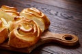 Homemade rose buns on wooden cutting board over rustic vintage background, close-up, shallow depth of field Royalty Free Stock Photo