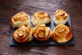 Homemade rose buns on wooden cutting board over rustic vintage background, close-up, shallow depth of field Royalty Free Stock Photo