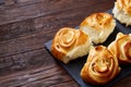 Homemade rose buns on wooden cutting board over rustic vintage background, close-up, shallow depth of field Royalty Free Stock Photo