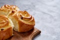 Homemade rose buns on wooden cutting board over white textured background, close-up, shallow depth of field Royalty Free Stock Photo