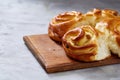 Homemade rose buns on wooden cutting board over white textured background, close-up, shallow depth of field Royalty Free Stock Photo