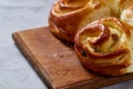 Homemade rose buns on wooden cutting board over white textured background, close-up, shallow depth of field Royalty Free Stock Photo