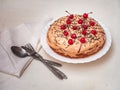 Homemade cake with sour cream, decorated with cocktail cherries, white napkin and cutlery lie on a light background Royalty Free Stock Photo