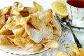 Homemade russian traditional cookies Brushwood on a white plate close-up, selective fokus. Rear cup of tea, slice lemon, sugar Royalty Free Stock Photo