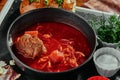 Red borsch made of beetrot, vegetables and meat with sour cream in a black plate on a copper background Royalty Free Stock Photo