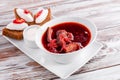 Homemade Russian, Ukrainian and Polish national soup - red borscht made of beetrot, vegetables and meat on white wooden Royalty Free Stock Photo