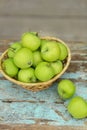 Homemade rustic green apples in a basket on an old stool. Royalty Free Stock Photo