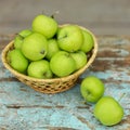 Homemade rustic green apples in a basket on an old stool. Royalty Free Stock Photo