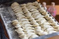 Homemade rustic homemade dumplings hand-sculpted on a tray in flour