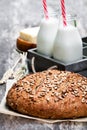 Homemade rye bread on baking paper and bottles of milk on woode Royalty Free Stock Photo