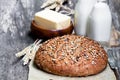 Homemade rye bread on baking paper and bottles of milk on woode Royalty Free Stock Photo