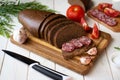 Homemade rye bread on a wooden board. Slices of rye bread on a platter. Sausage sandwich Royalty Free Stock Photo