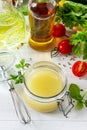 Homemade salad dressing vinaigrette with mustard, olive oil, lemon juice and various fresh vegetables and herbs Royalty Free Stock Photo
