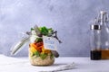 Homemade salad in glass jar with quinoa and vegetables with label lunch time no plastic and take