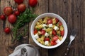 Homemade salad with pasta, tomatoes, feta cheese and spices on wooden table with ingredients