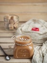 Homemade salted caramel sauce in a glass jar on a rustic wooden table. Close-up. Selective focus, vertical orientation Royalty Free Stock Photo