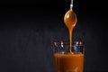 Homemade salted caramel sauce in a jar on a dark background. copy space text Royalty Free Stock Photo