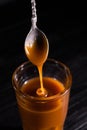 Homemade salted caramel sauce in a jar on a dark background. copy space text Royalty Free Stock Photo