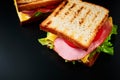 Homemade sandwich with lettuce and ham on a black background, close up Royalty Free Stock Photo