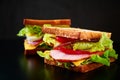 Homemade sandwich with lettuce and ham on a black background, close up Royalty Free Stock Photo