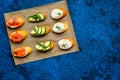 Homemade sandwiches with french baguette, salmon, cheese and vegetable on blue background top view mock-up