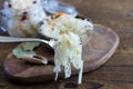 Homemade sauerkraut or barrel cabbage on a fork on a rustic wooden background. In the background is a bowl of cabbage. Royalty Free Stock Photo