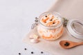 Glass jar with homemade sauerkraut, black pepper on a gray table. Copy space