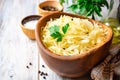 Homemade sauerkraut with black pepper and parsley in wooden bowl on rustic background